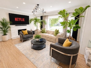 Ein modernes Wohnzimmer mit Kamin, Fernseher und bequemen Sitzgelegenheiten.