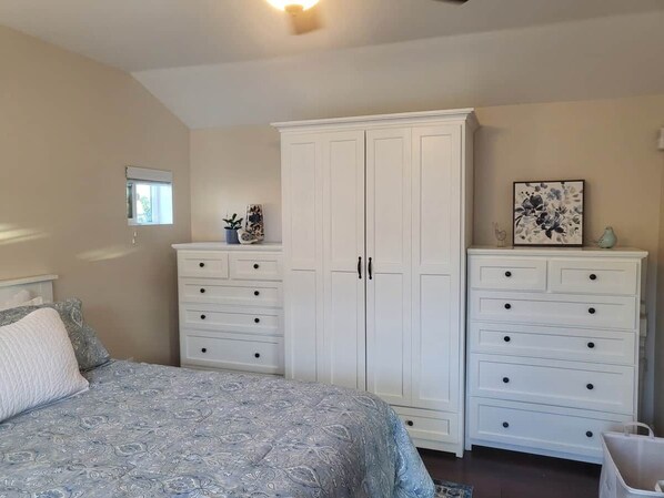 A bedroom with a bed, two white dressers, a window, and a ceiling light. - Private, Charming Cottage! Perfect for Long Stays! (La Mesa)