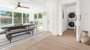 A bright kitchen with a dining area, large windows, and a ceiling fan. - Delila's Chic 3 Bedroom-2 bath w/ Heated Pool + Game Room (Deerfield Beach)