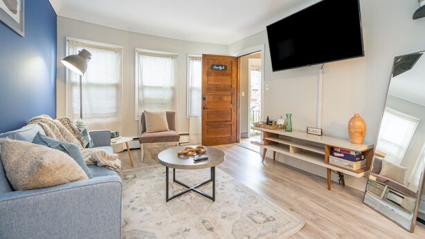 Una sala de estar moderna con sofá, mesa de centro y televisor.