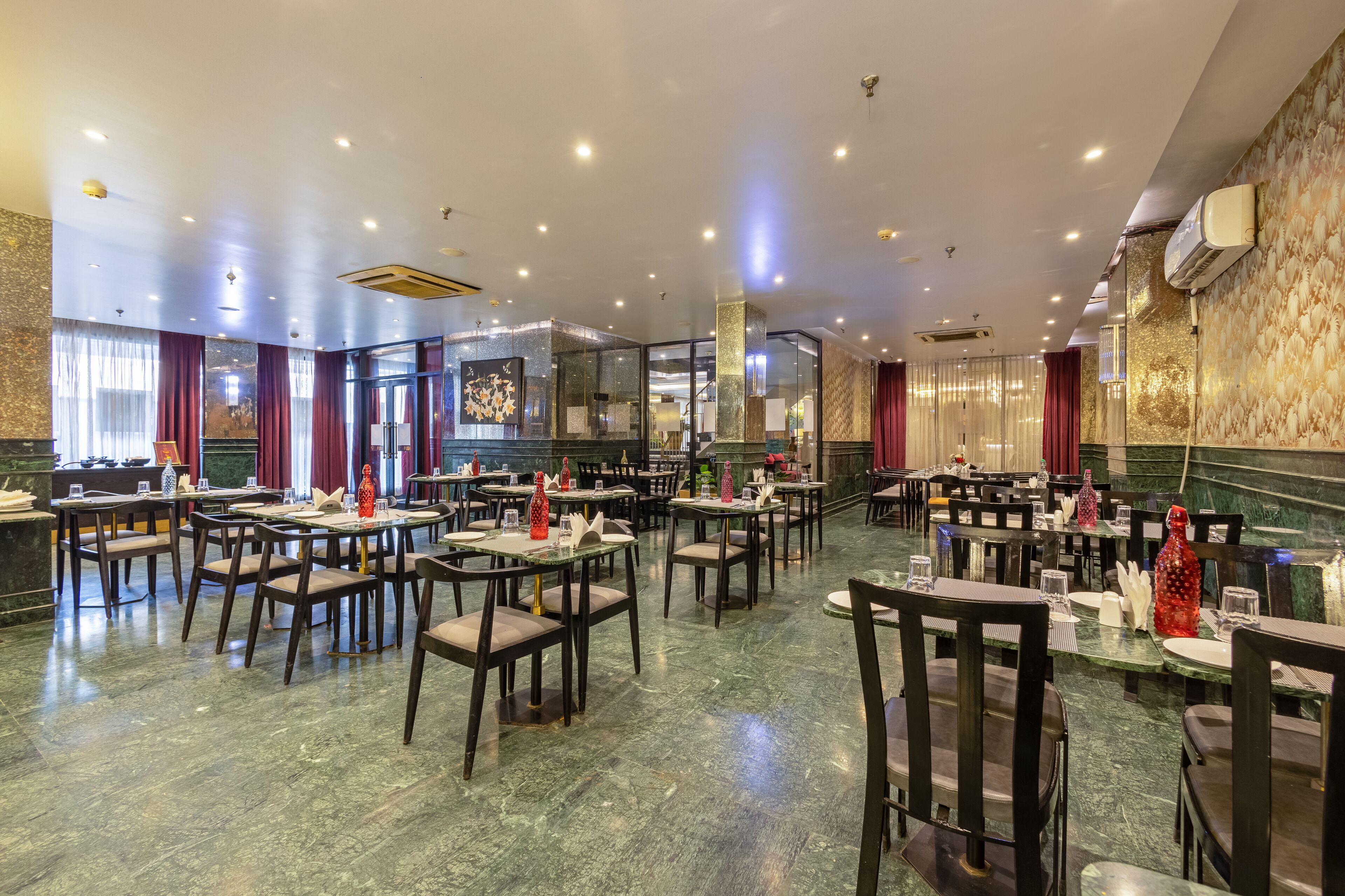 Un restaurante espacioso con suelos de mármol, varias mesas y sillas.