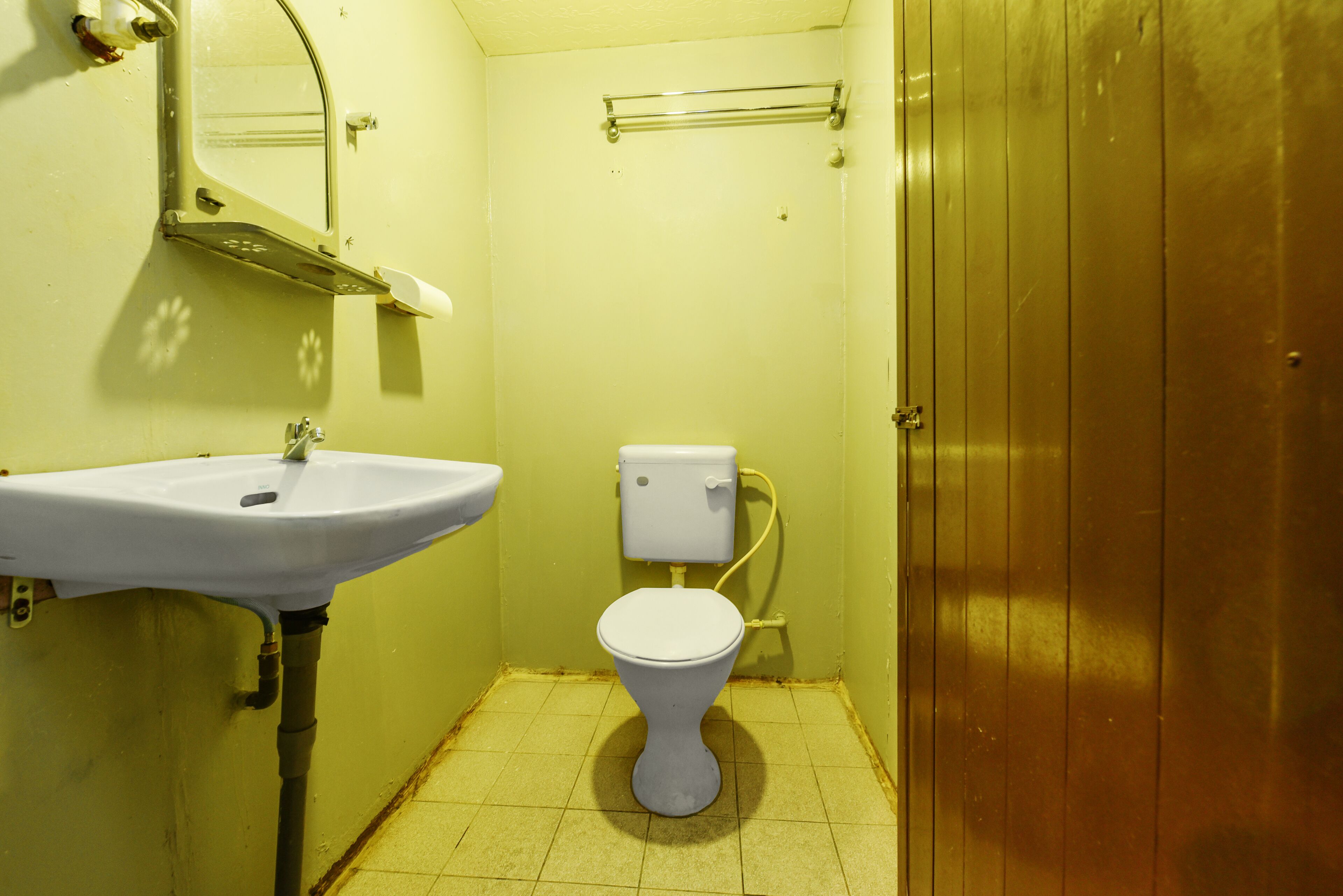 A small bathroom with a white sink, a toilet, and a mirror.