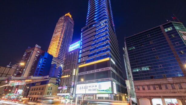 A high-rise building with illuminated signage, including a prominent Panasonic sign. - Roaders Plus Hotel Taipei Station (Taipei)