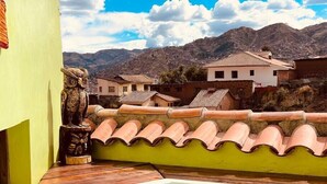 A hot tub with a view of a mountain range and traditional buildings in the background. - Historic Cusco ∞ Experience Luxury ∞ El Nuevo Sol ∞ Staffed Villa (Cusco)