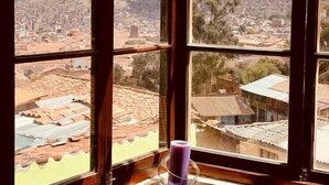 A room with a large window offering a view of a cityscape and mountains. - Historic Cusco ∞ Experience Luxury ∞ El Nuevo Sol ∞ Staffed Villa (Cusco)