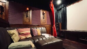 A cozy room with a leather sofa, wooden paneling, and a large screen for viewing. - Historic Cusco ∞ Experience Luxury ∞ El Nuevo Sol ∞ Staffed Villa (Cusco)