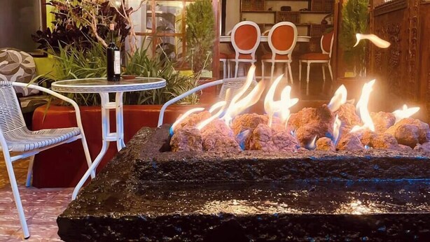 A cozy outdoor seating area with a fire feature, wicker chairs, and a table. - Historic Cusco ∞ Experience Luxury ∞ El Nuevo Sol ∞ Staffed Villa (Cusco)