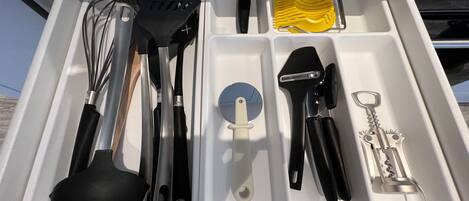 Un cajón de cocina con utensilios y herramientas.