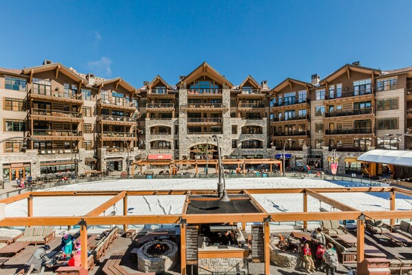 A multi-story hotel with a central courtyard, outdoor seating, and a fire pit.