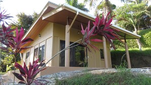 Een modern huis met een plat dak, grote ramen en een overdekte veranda.