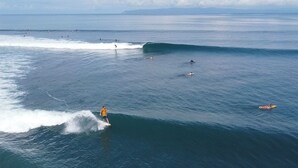 Een kustgezicht met surfers en zwemmers in de oceaan.