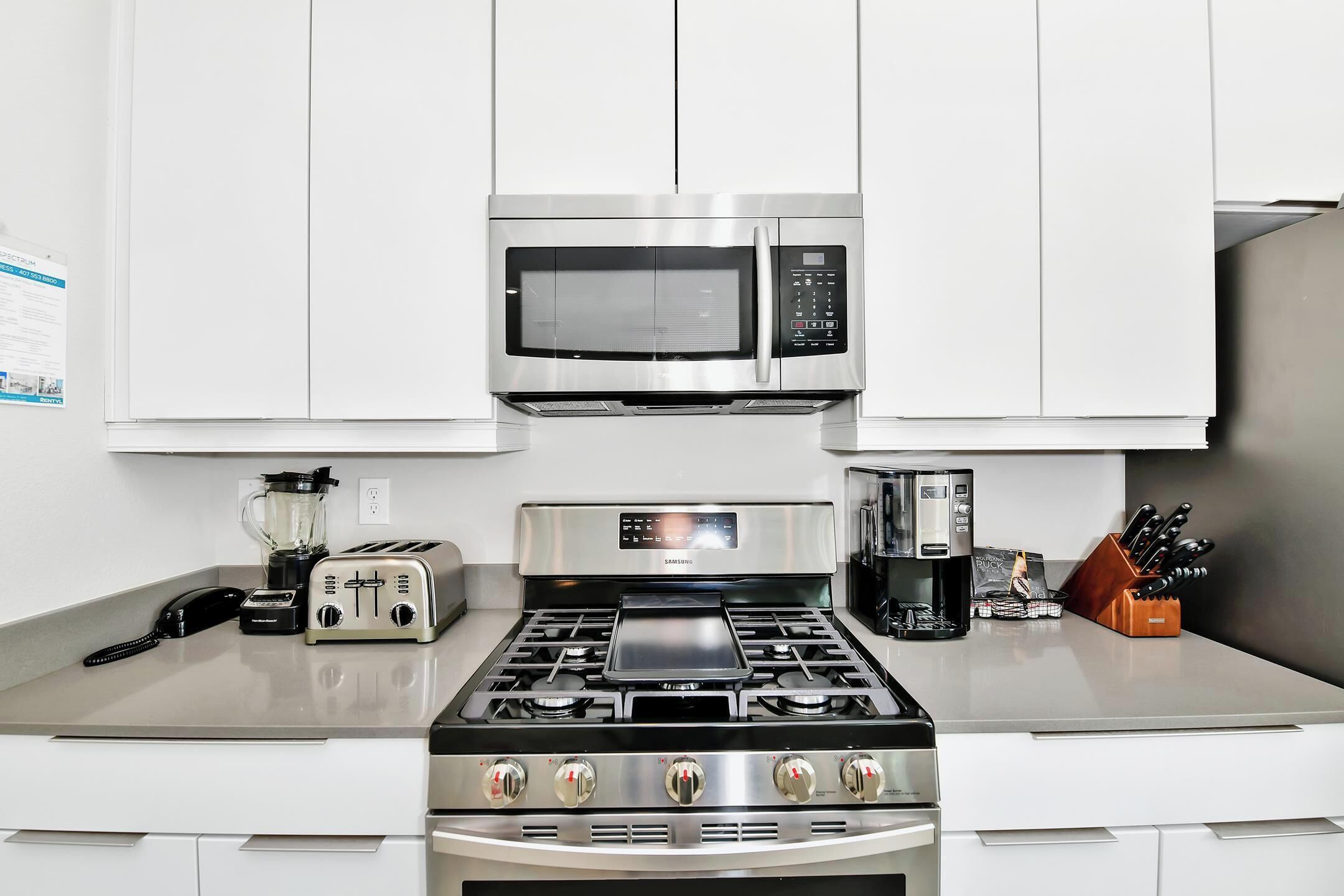 A modern kitchen with a stainless steel stove, microwave, and toaster.