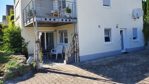En tvåvåningsbyggnad med en balkong, utomhusplatser och en satellantenn.