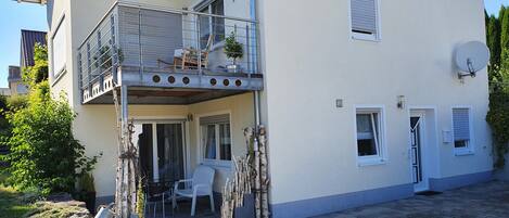 A two-story building with a balcony, outdoor seating, and a satellite dish.