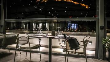 A restaurant with a view of a cityscape at night.