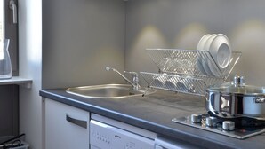 A modern kitchen with a stainless steel sink, a dish rack, and a stove. - Renovated Divisible Studio at the Foot of the Slopes with Balcony and Pets Allowed (Plagne Bellecôte)