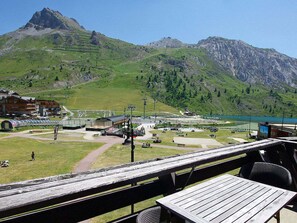 Vista de montanhas com restaurante e teleférico em primeiro plano.