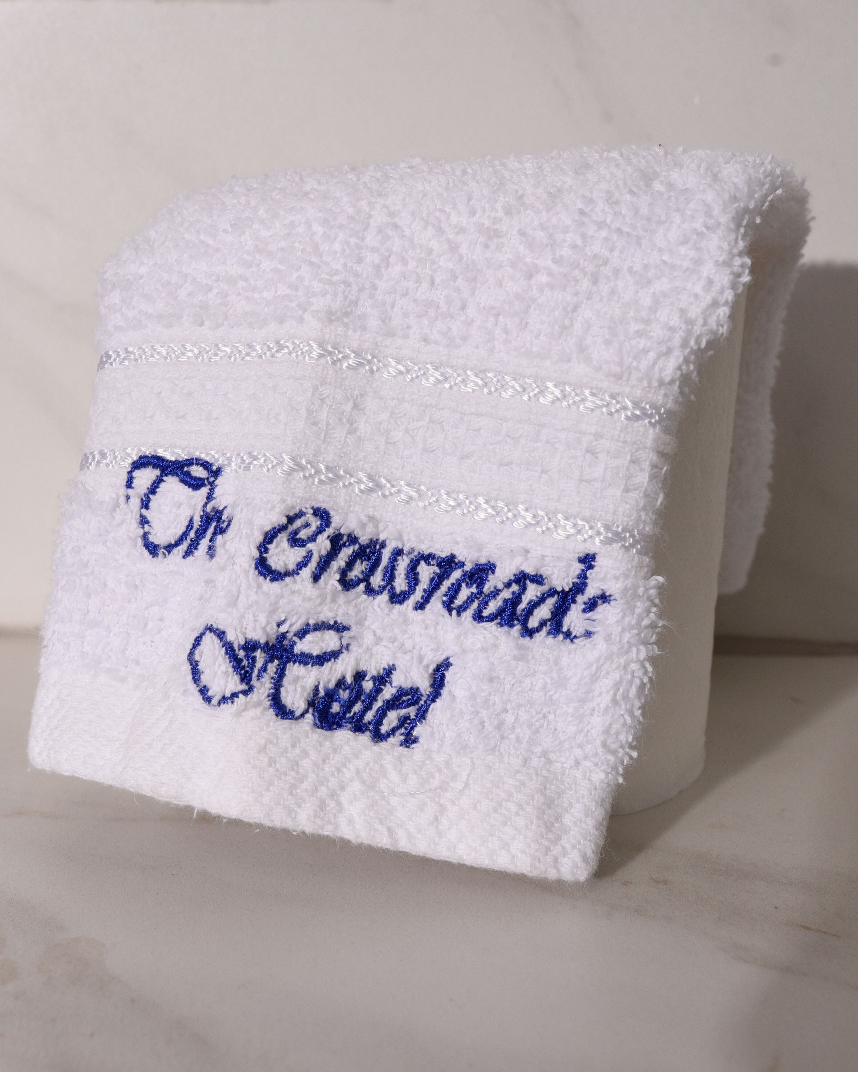 Una toalla blanca con texto bordado.