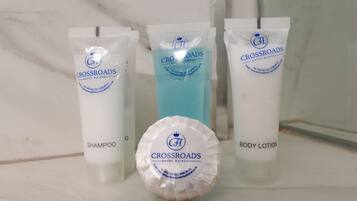 Tres productos del Crossroads Hotel Nairobi: champú, loción corporal y un líquido azul.