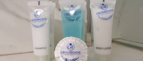 Tres productos del Crossroads Hotel Nairobi: champú, loción corporal y un líquido azul.