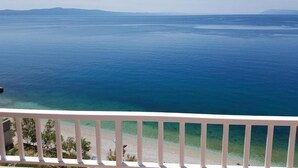 A balcony with a view of a calm sea and distant mountains. - Apartments Jereb (Podgora)