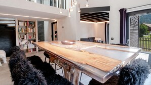 Een moderne keuken met een groot eiland, hanglampen en uitzicht op de omgeving.