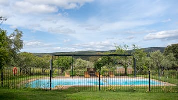 Una piscina al aire libre de temporada, tumbonas
