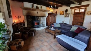 Ein gemütliches Wohnzimmer mit Kamin, Ledersofa und Esstisch.
