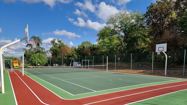 An outdoor basketball court with a green playing surface, red boundary lines, and two basketball hoops. - Prachtig oud Frans huis gelegen in de Lot, met privé zwembad middenin de natuur. (Sérignac)