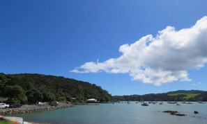 A scenic view of Mill Bay with boats on the water and a road leading to the beach. - Mill Bay Charmer (Mangonui)