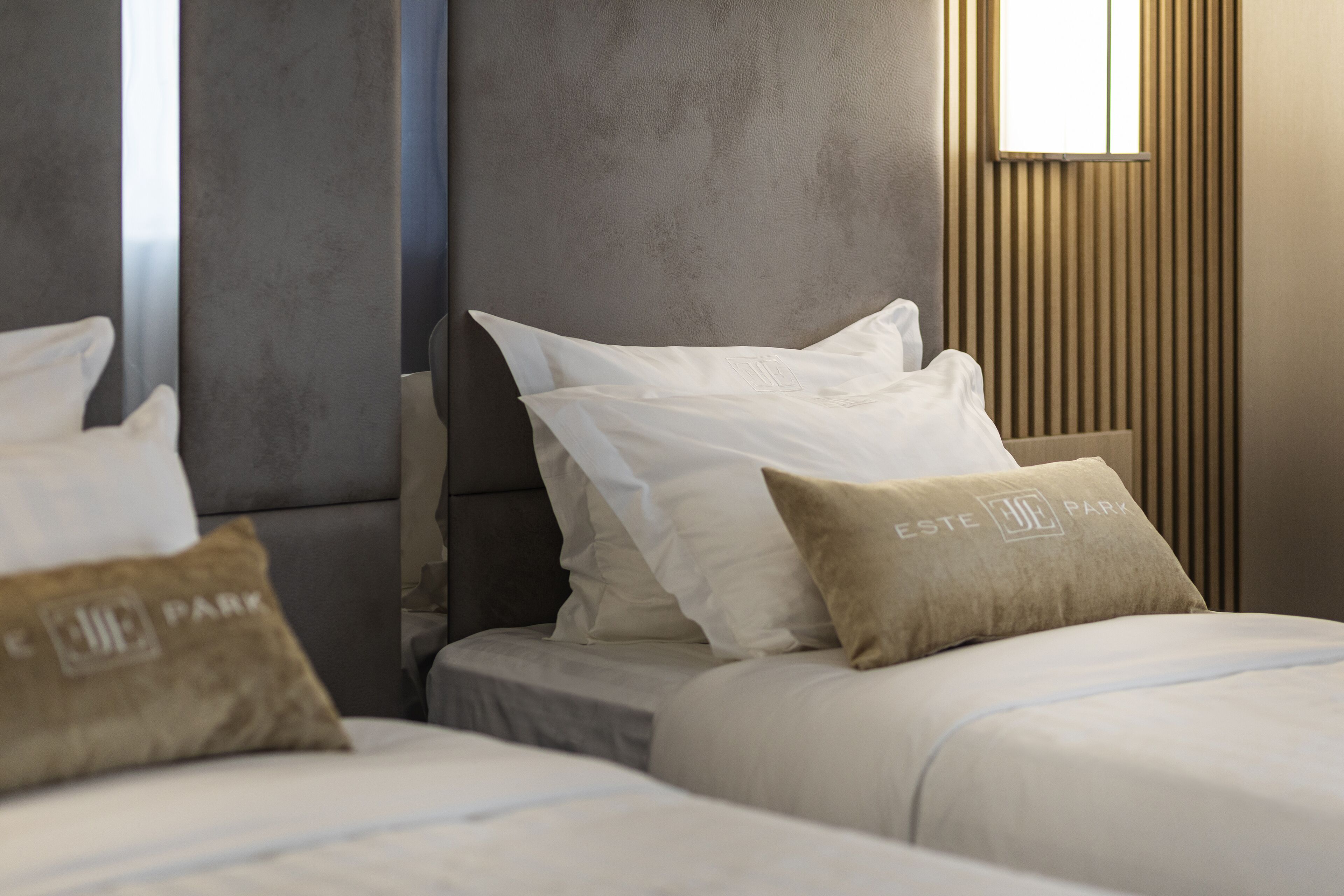 A hotel room with a bed, pillows, and a headboard.