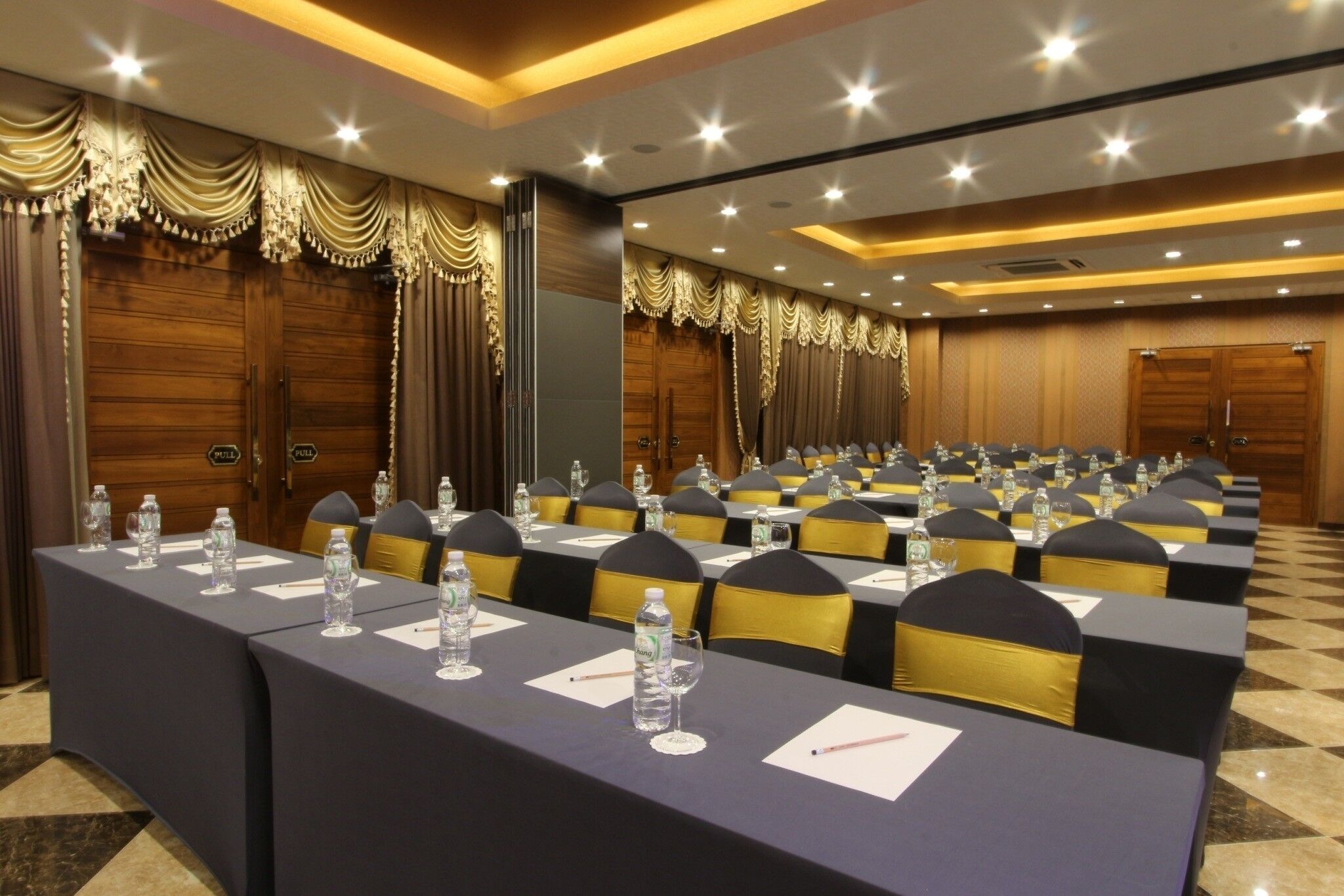 A conference room with long tables, chairs, and water bottles.