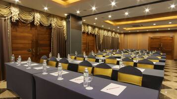 A conference room with long tables, chairs, and water bottles.