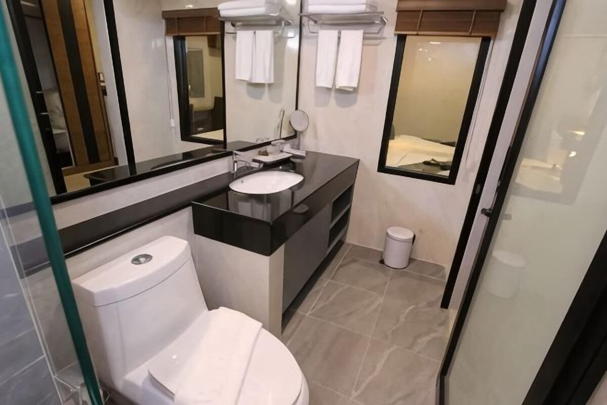 Un baño moderno con inodoro, lavamanos y espejo.