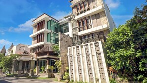 A multi-story building with a modern architectural style, featuring balconies, large windows, and a gated entrance. - Palette near Legian Beach formerly Argya Santi Suites And Villas (Legian)