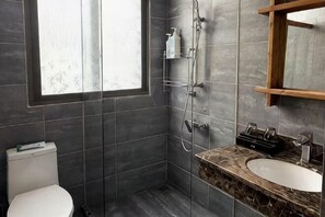 A bathroom with a toilet, a sink, a shower, and a window. - Hillside Mercure Zixing (Zixing)