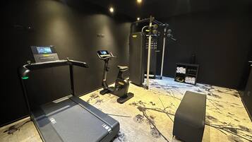 A gym with a treadmill, an elliptical, and a weight machine.