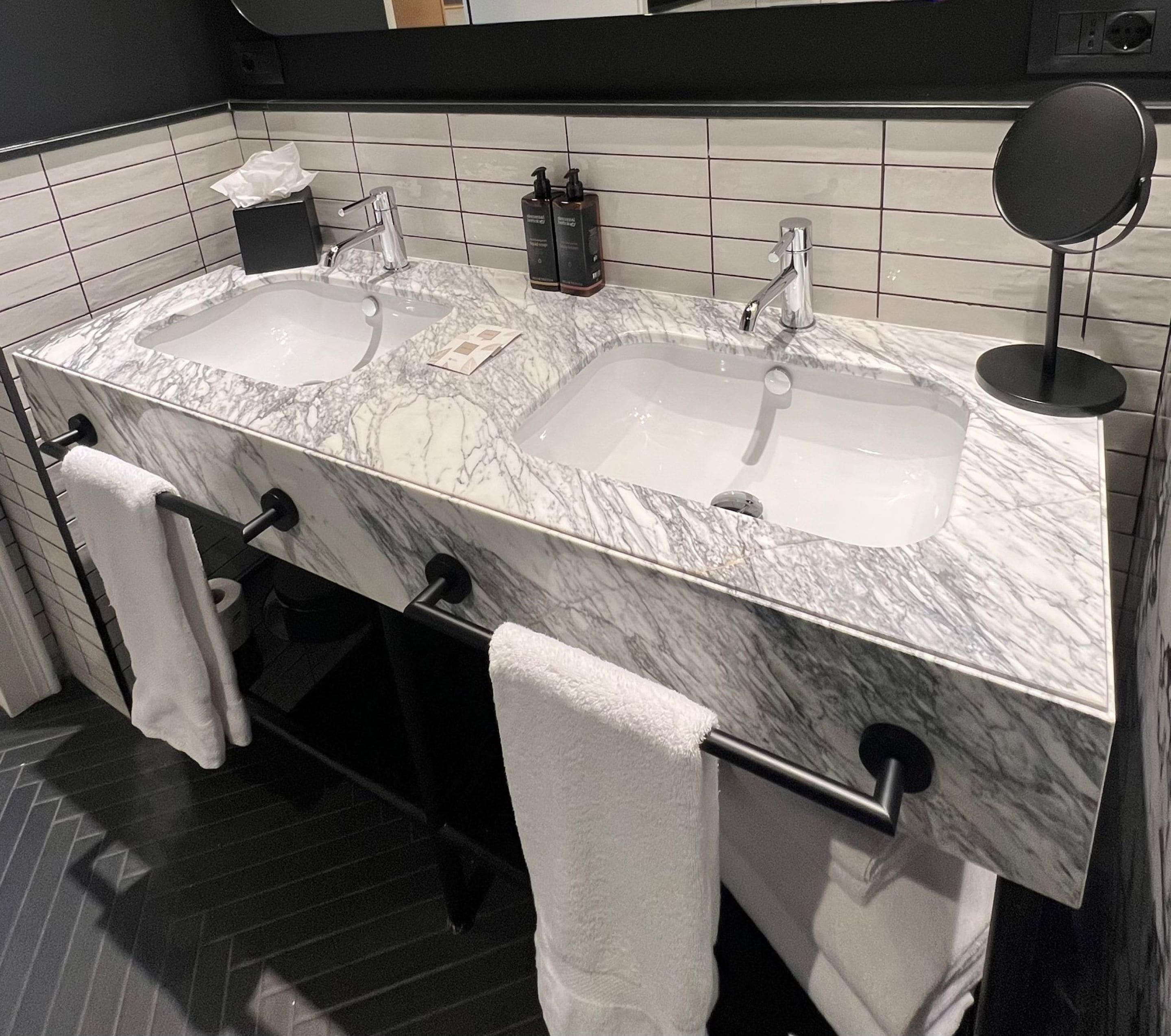 A bathroom with two sinks, a mirror, and towels.