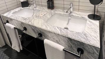 A bathroom with two sinks, a mirror, and towels.