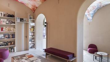 Un interior moderno con una mesa de centro de mármol, un banco rojo y estanterías llenas de libros.