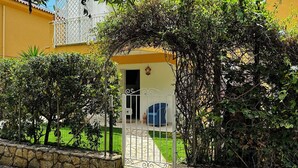 Un edificio giallo con un cancello bianco e un piccolo giardino.