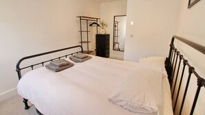 A bedroom with a single bed, a bedside table, and a wardrobe.