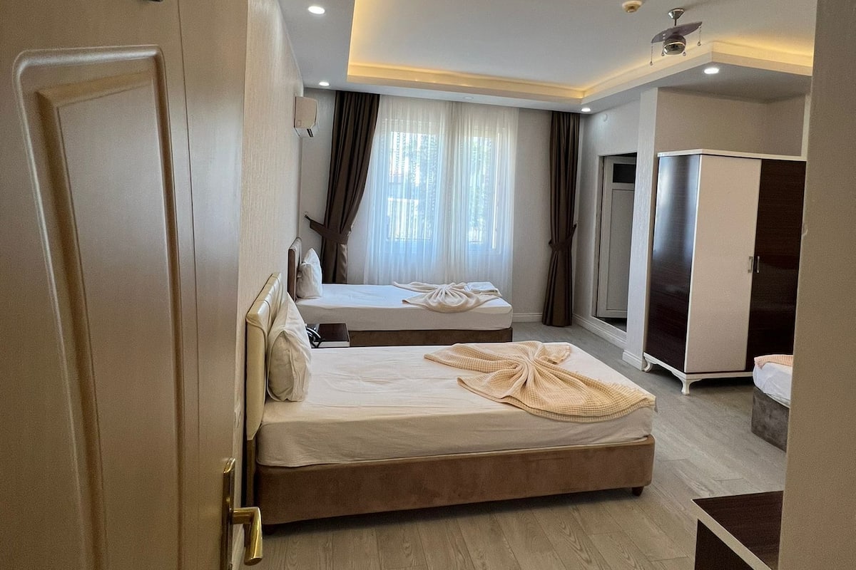 Ein modernes Hotelzimmer mit einem großen Bett, einer separaten Sitzecke, einem Kleiderschrank und einem Badezimmer.