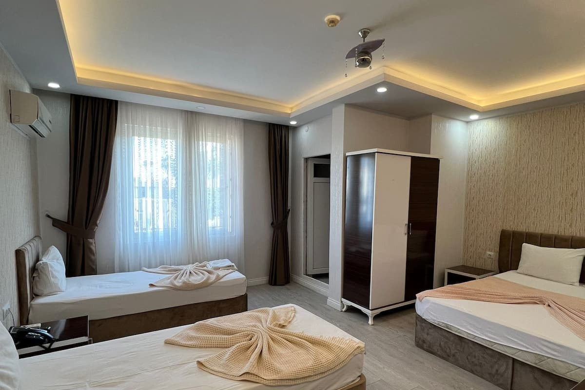 Ein Hotelzimmer mit zwei Betten, einem Schrank, einem Schreibtisch und einem Badezimmer.