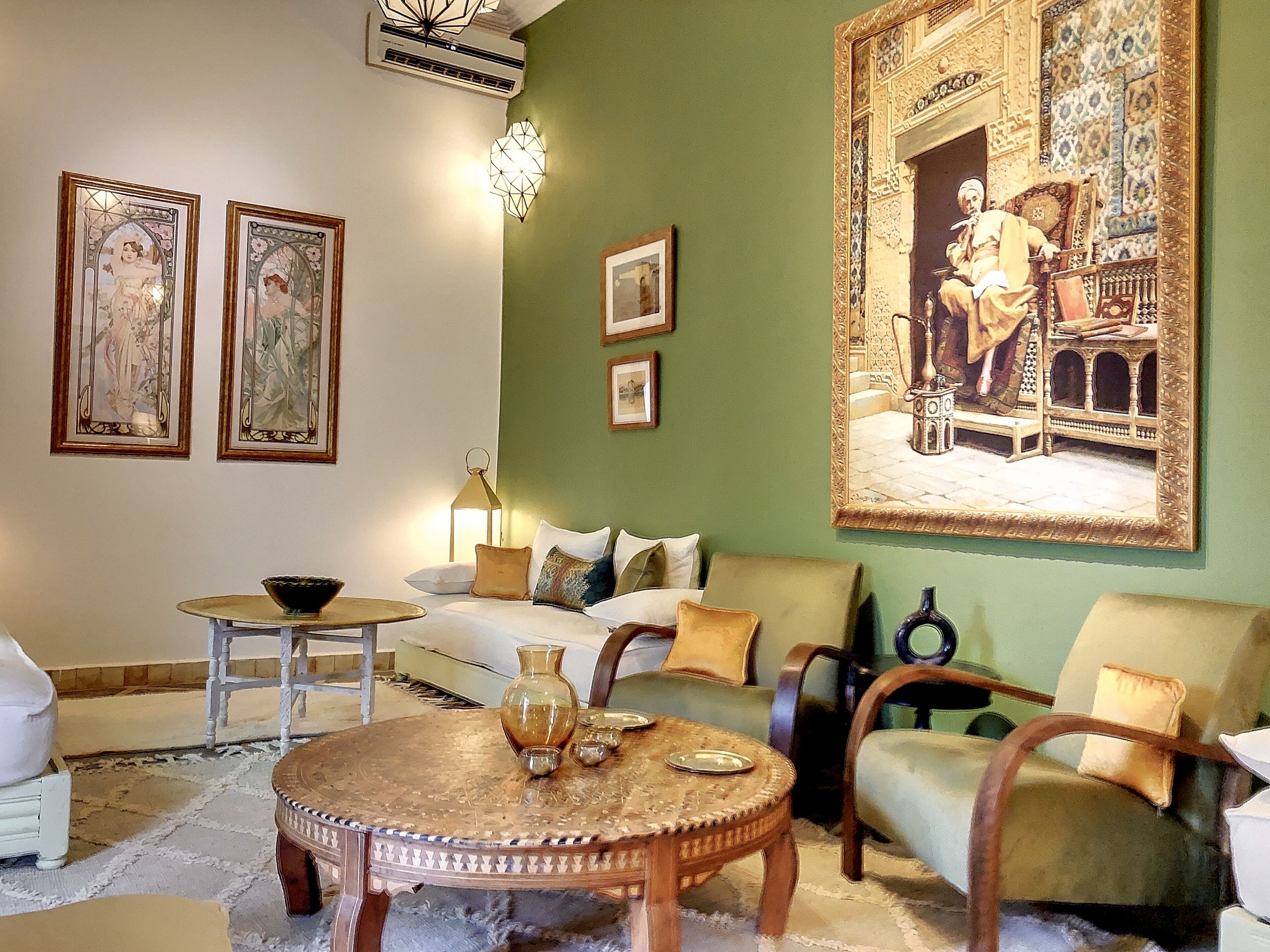 Un salon avec une table basse ronde en bois, un canapé et un grand tableau encadré accroché au mur.