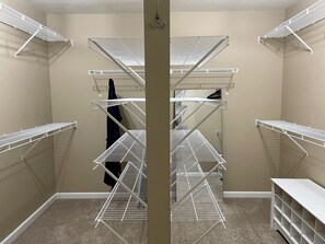 A walk-in closet with multiple white metal shelving units.