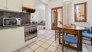 Una cocina compacta equipada con microondas y horno, y un comedor con mesa y sillas.