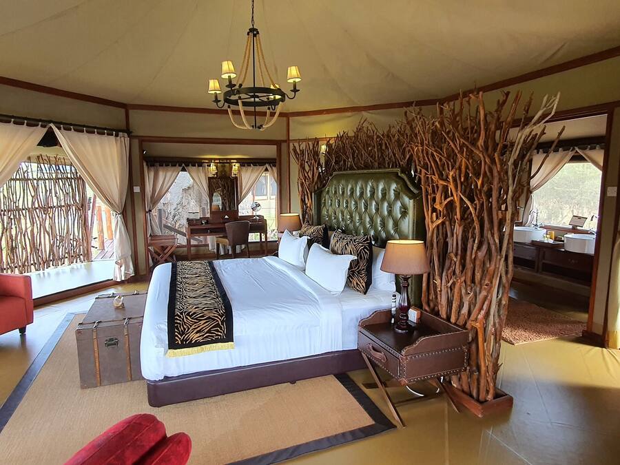 Ein geräumiges Schlafzimmer mit einem großen Bett, einer Sitzecke mit Sofa, Schreibtisch und Stuhl.