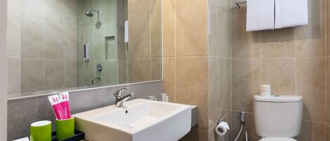 A modern bathroom with a white sink, a mirror, a toilet, and a shower.