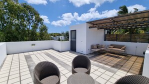 A rooftop terrace with a seating area, a door, and a pergola. - Villa with pool 5 minutes from the beach! (Trou-aux-Biches)